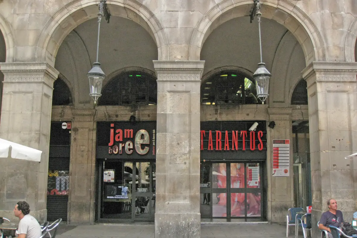 The arcade at Plaça Reial 17 in a 2011 photograph, with a red TARANTOS sign over a glass door beside a neighbouring music club